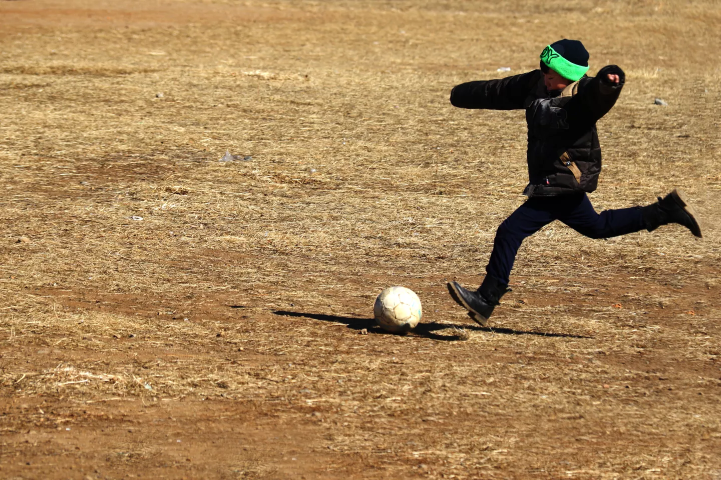 Mongolia, 2017 A boy playing football outside a local elementary school in Nalaikh District, Ulaanbaatar, Mongolia